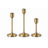 Three brushed-metal candle holders with antique brass finish and weighted bases, shown as a set of three.