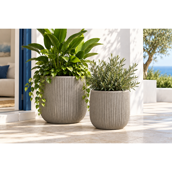 Pair of ribbed planters with green plants in an outdoor setting.