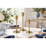 Three candle holders styled together on a dining table.